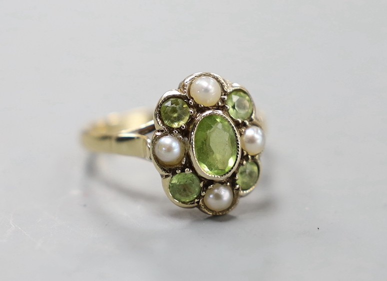 An early 20th century yellow metal, peridot and split pearl cluster set dress ring, size N, gross weight 3 grams.